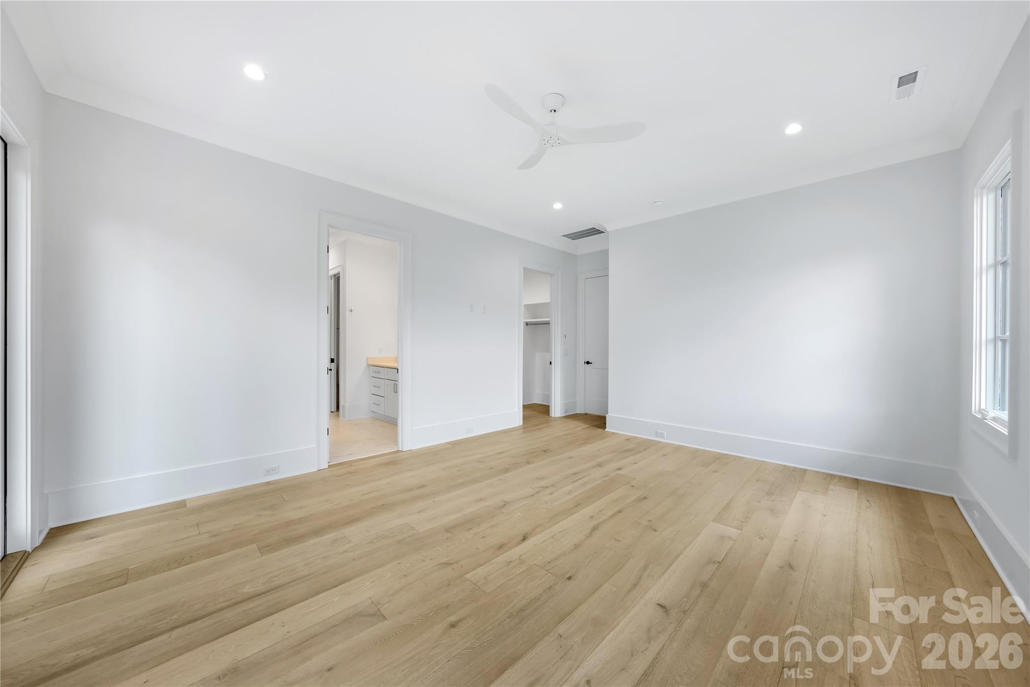 5035 Gilchrist Road, Unit 1B Charlotte, NC 28211 - Photo 34 of 46 a view of an empty room with wooden floor and a window