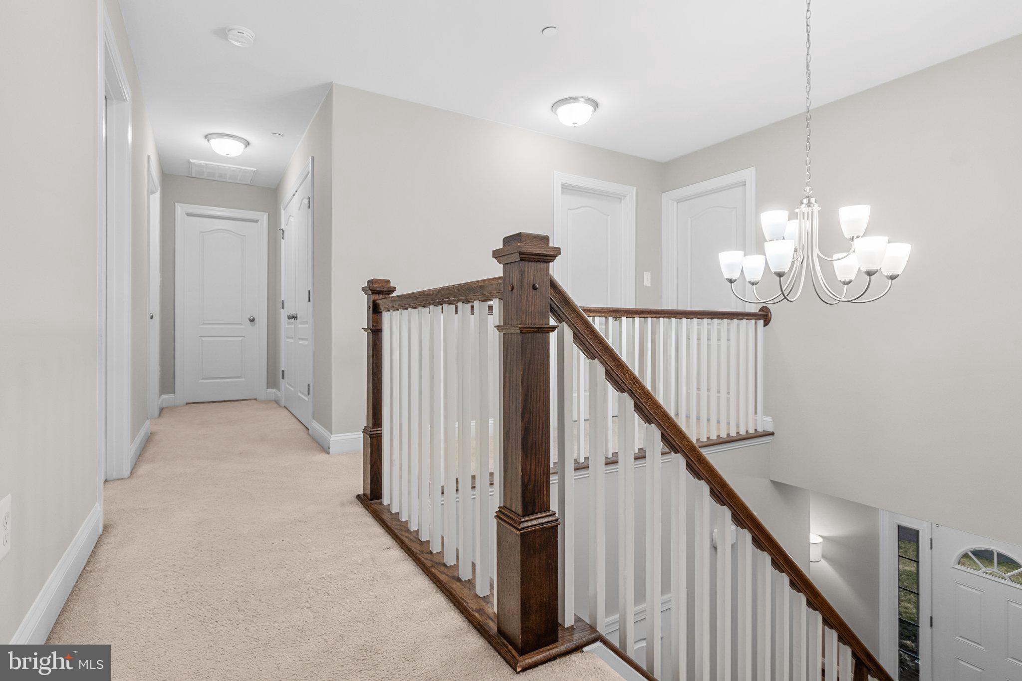 4554 Coachmans Path Court Waldorf, MD 20601 - Photo 15 of 40 Elegant staircase in a serene hallway.