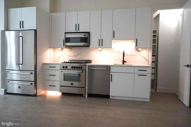 a kitchen with stainless steel appliances a refrigerator sink and microwave