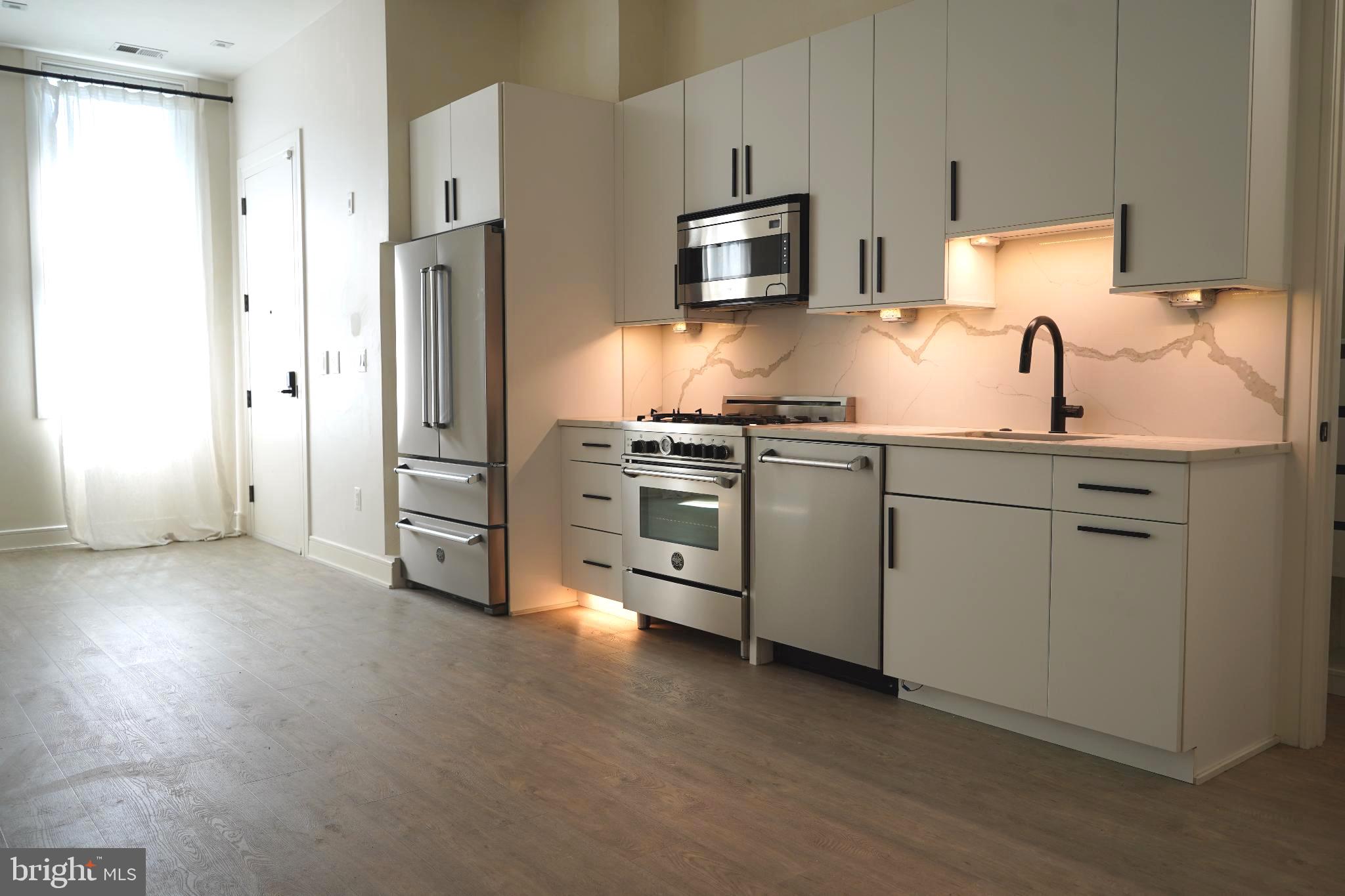 725 Euclid Street Northwest, Unit 2 Washington, DC 20001 - Photo 5 of 14 a kitchen with stainless steel appliances a refrigerator sink and microwave