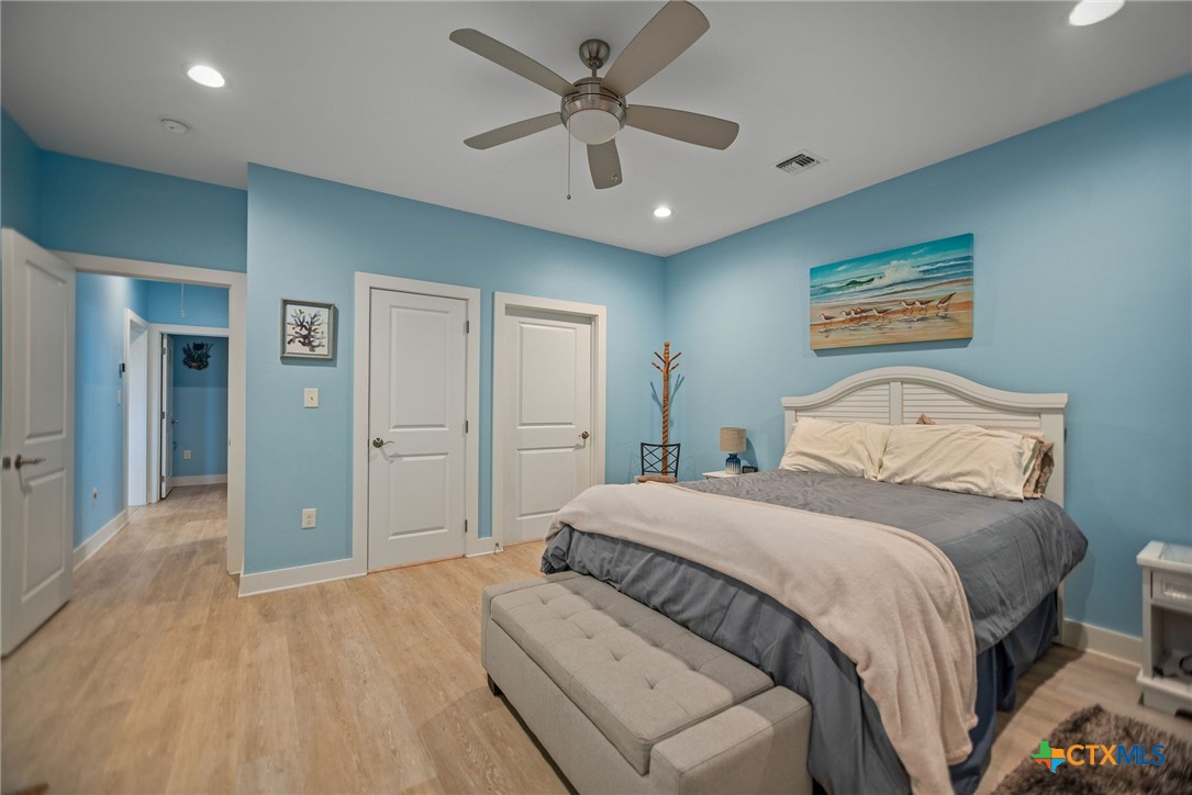 1383 Bay Point Drive Port Lavaca, TX 77979 - Photo 17 of 32 a bedroom with a large bed and a chandelier