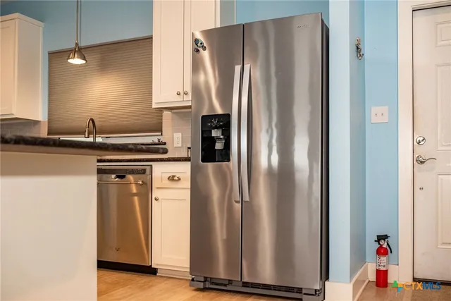 a kitchen with stainless steel appliances granite countertop a refrigerator and a sink