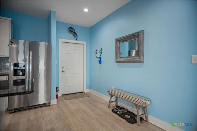 a room with a bench and a refrigerator