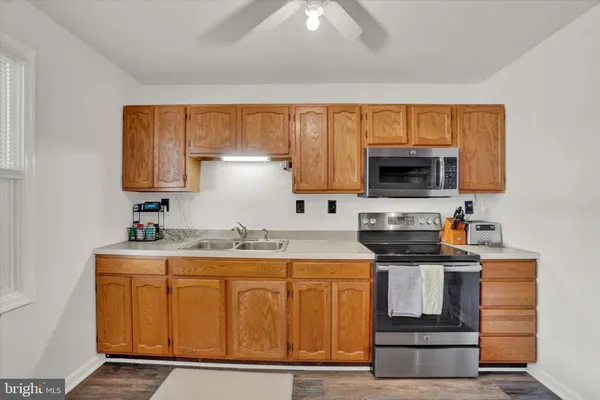 a kitchen with stainless steel appliances granite countertop a stove a sink and a microwave