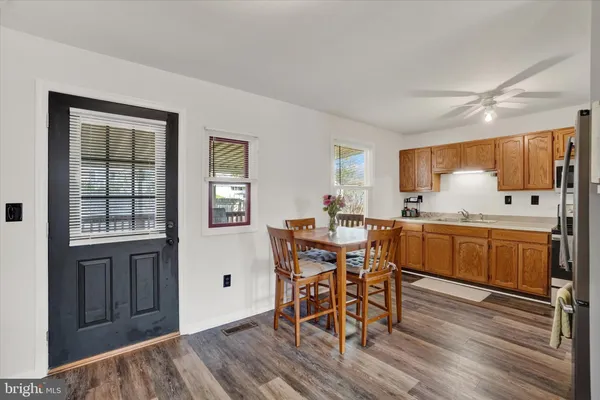 a kitchen with stainless steel appliances granite countertop a kitchen island hardwood floor sink and stove