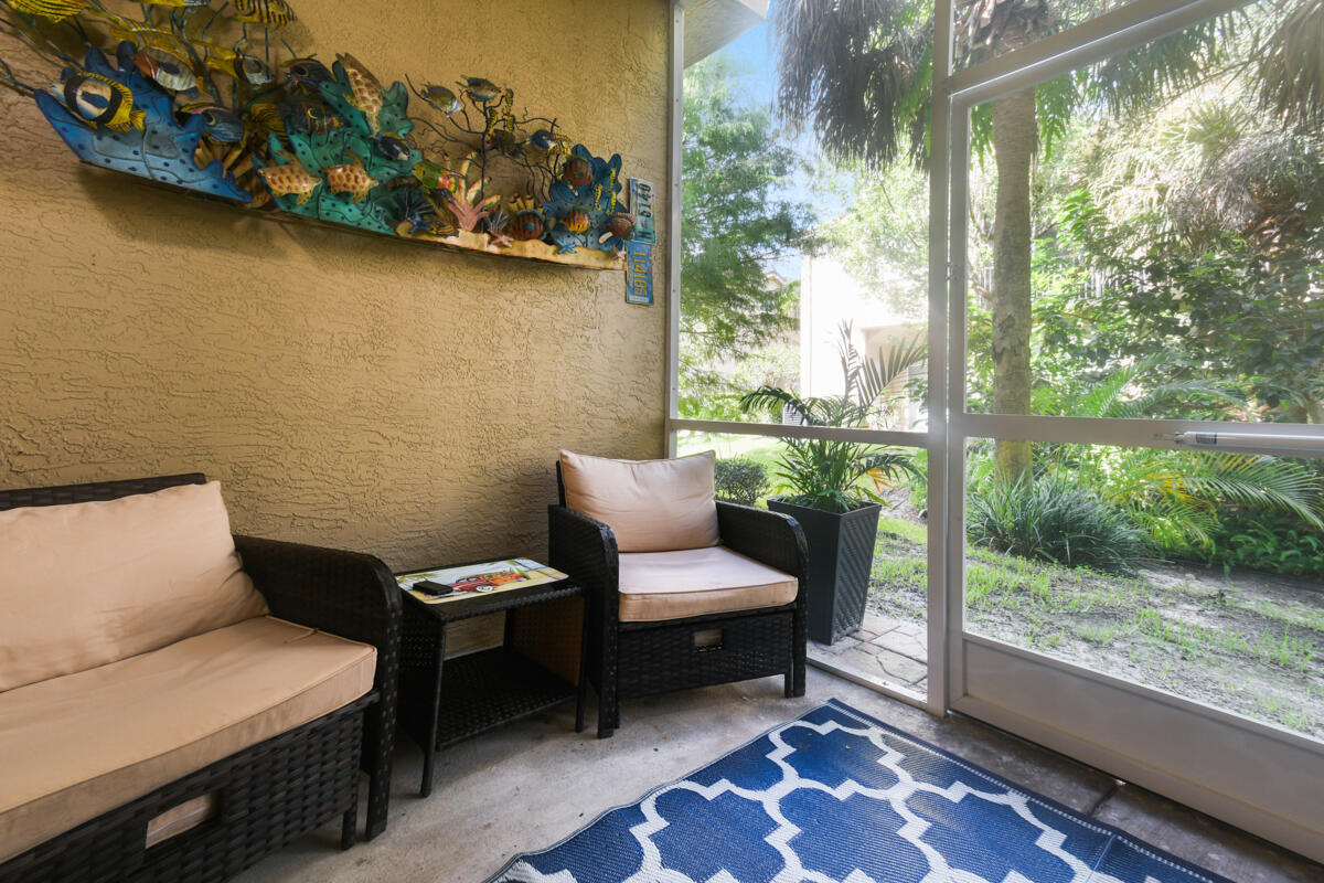 105 Lighthouse Circle, Unit D Tequesta, FL 33469 - Photo 20 of 36 a balcony with wooden benches and a couch