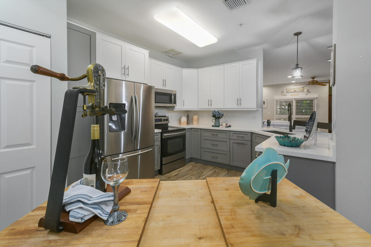 105 Lighthouse Circle, Unit D Tequesta, FL 33469 - Photo 2 of 36 a kitchen with kitchen island a counter top space appliances and cabinets