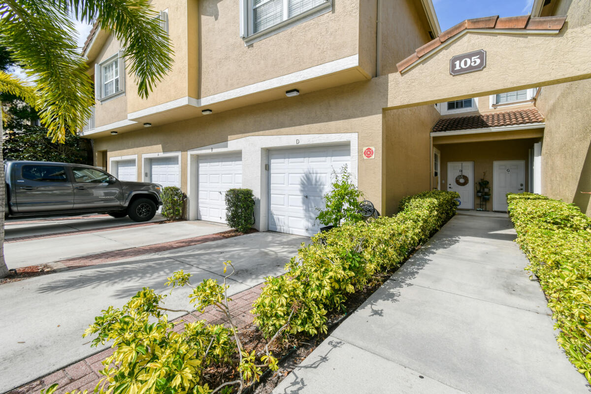 105 Lighthouse Circle, Unit D Tequesta, FL 33469 - Photo 22 of 36 a front view of a house with potted plants