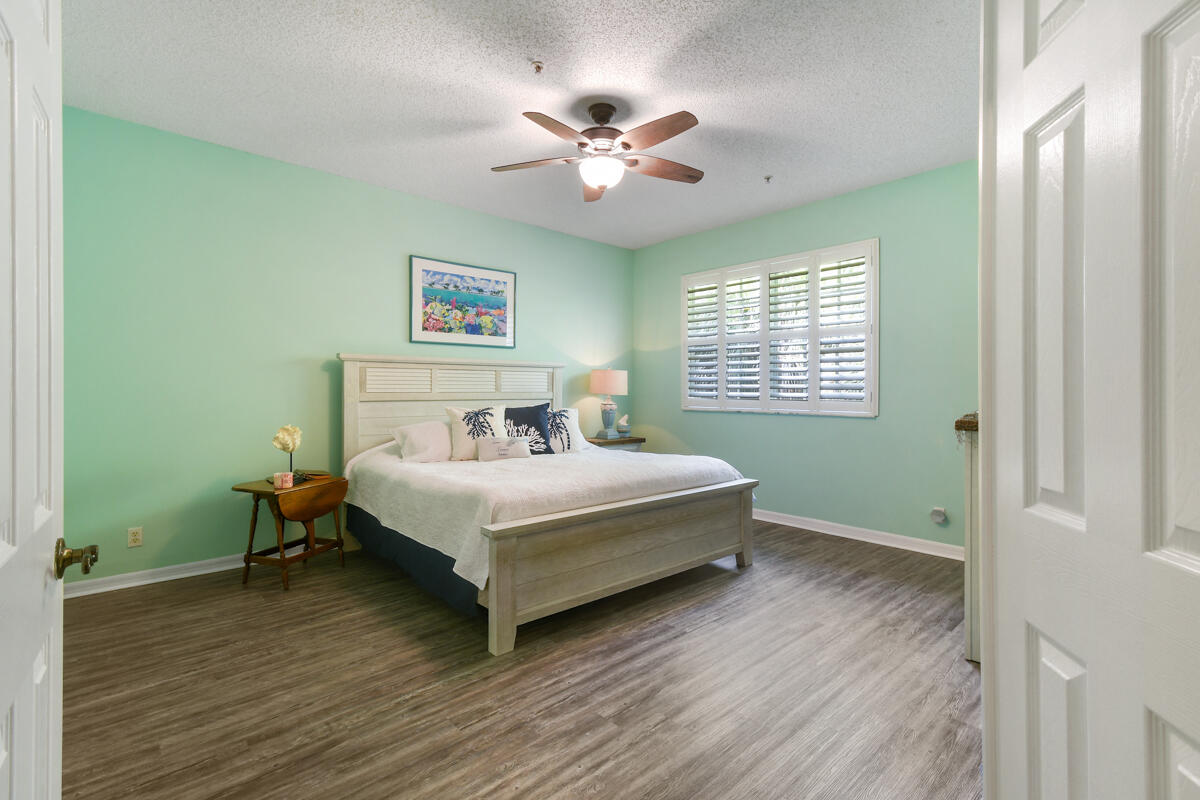 105 Lighthouse Circle, Unit D Tequesta, FL 33469 - Photo 24 of 36 a bedroom with a bed and a window