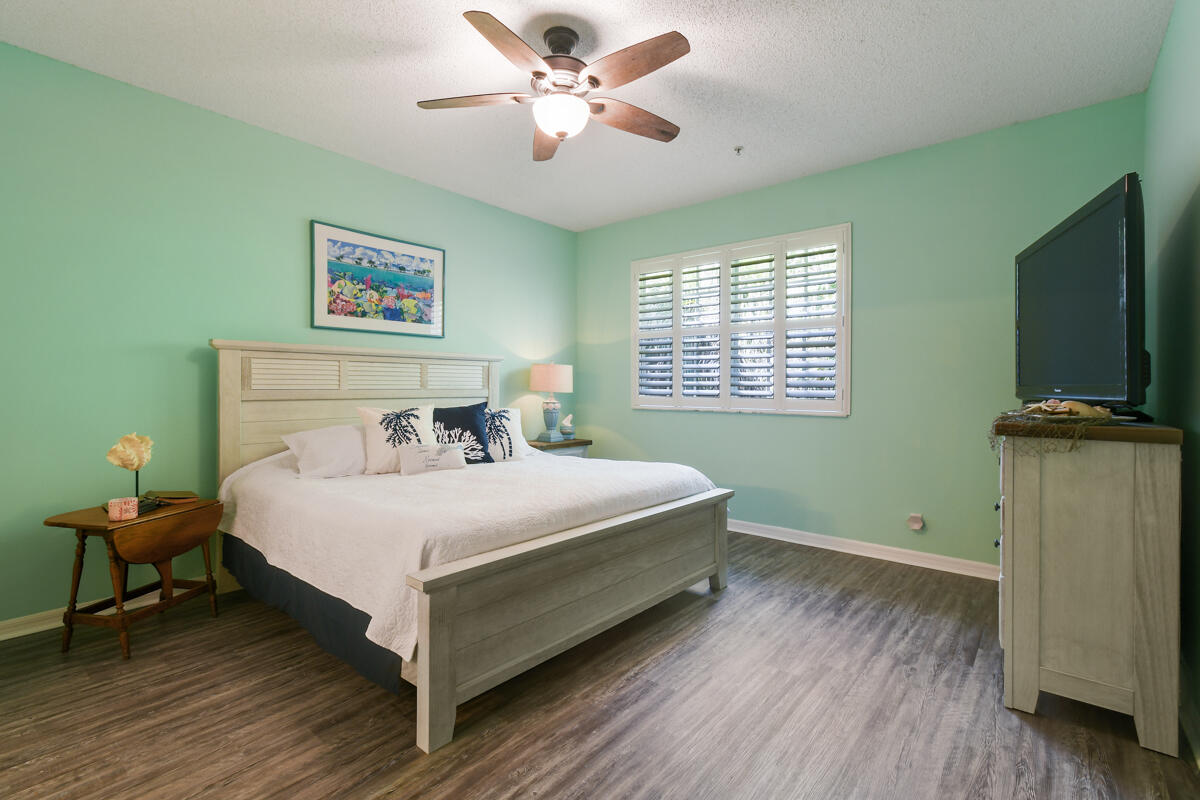 105 Lighthouse Circle, Unit D Tequesta, FL 33469 - Photo 25 of 36 a bedroom with a bed and a flat screen tv