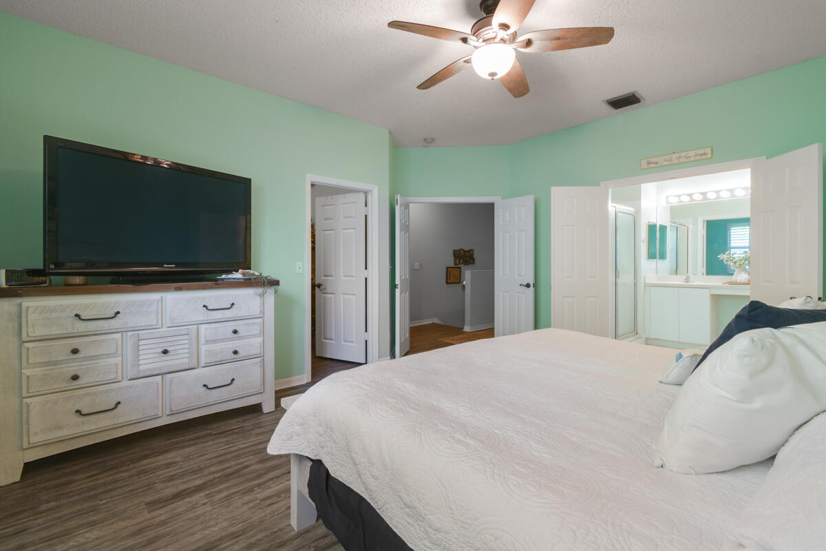 105 Lighthouse Circle, Unit D Tequesta, FL 33469 - Photo 27 of 36 a bedroom with a bed and a flat screen tv
