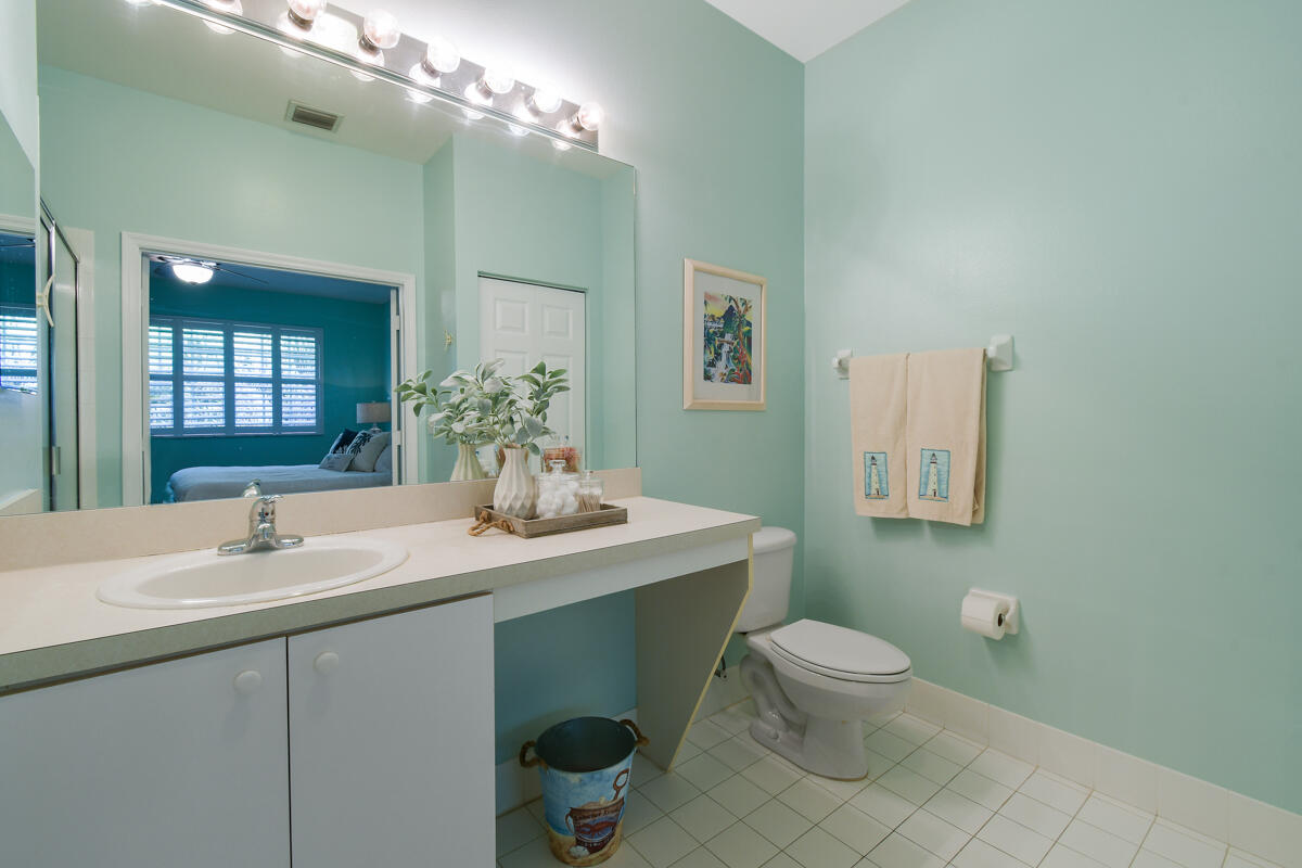 105 Lighthouse Circle, Unit D Tequesta, FL 33469 - Photo 29 of 36 a bathroom with a toilet sink and mirror