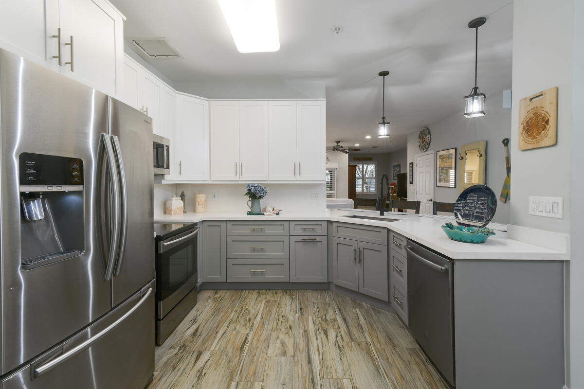 105 Lighthouse Circle, Unit D Tequesta, FL 33469 - Photo 3 of 36 a kitchen with a sink stainless steel appliances and cabinets