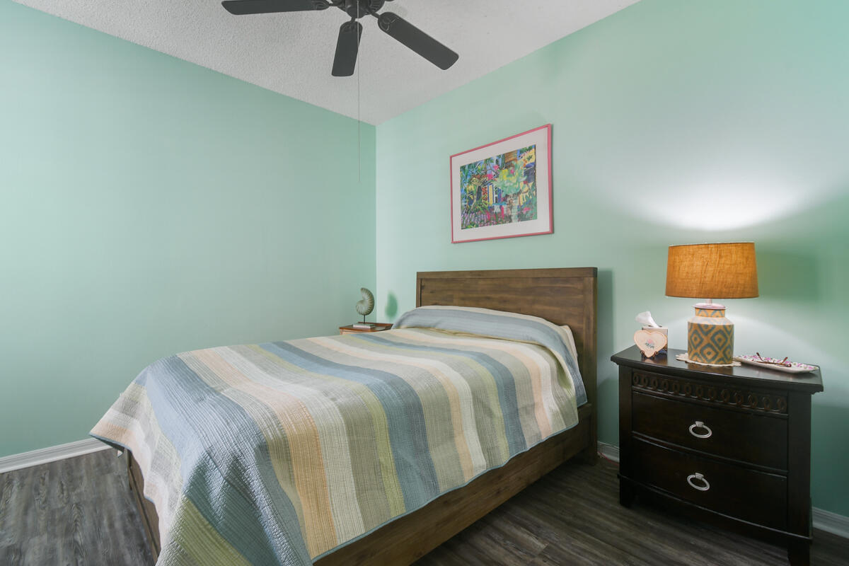 105 Lighthouse Circle, Unit D Tequesta, FL 33469 - Photo 31 of 36 a bedroom with a bed and wooden floor