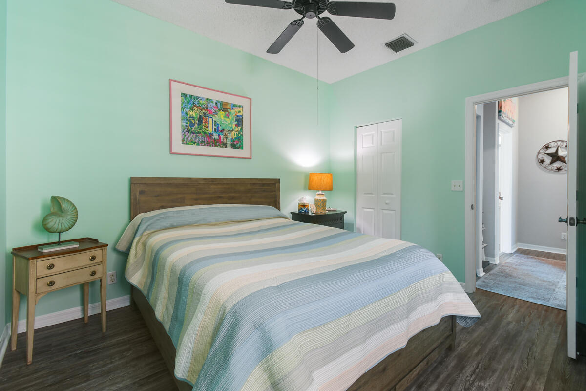 105 Lighthouse Circle, Unit D Tequesta, FL 33469 - Photo 32 of 36 a bedroom with a bed and a painting on the wall
