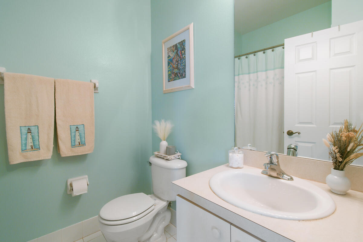 105 Lighthouse Circle, Unit D Tequesta, FL 33469 - Photo 33 of 36 a bathroom with a sink toilet and a mirror