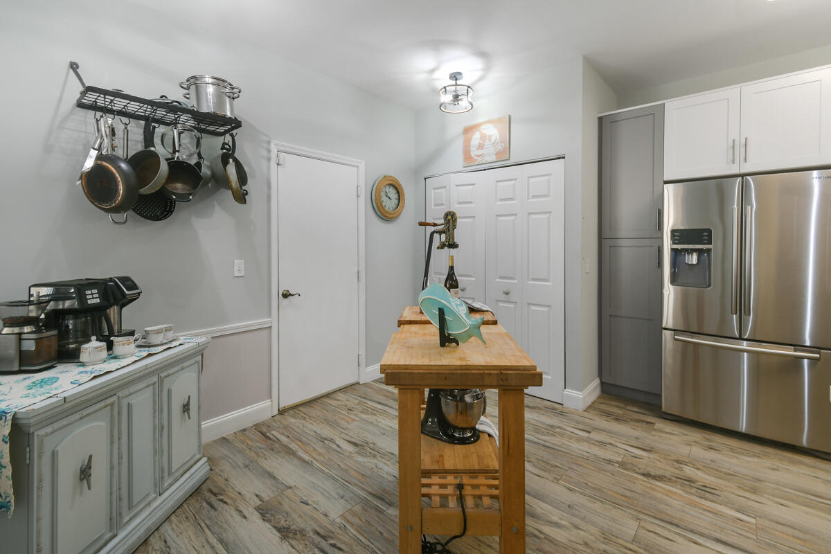 105 Lighthouse Circle, Unit D Tequesta, FL 33469 - Photo 5 of 36 a kitchen with stainless steel appliances wooden floor and sink