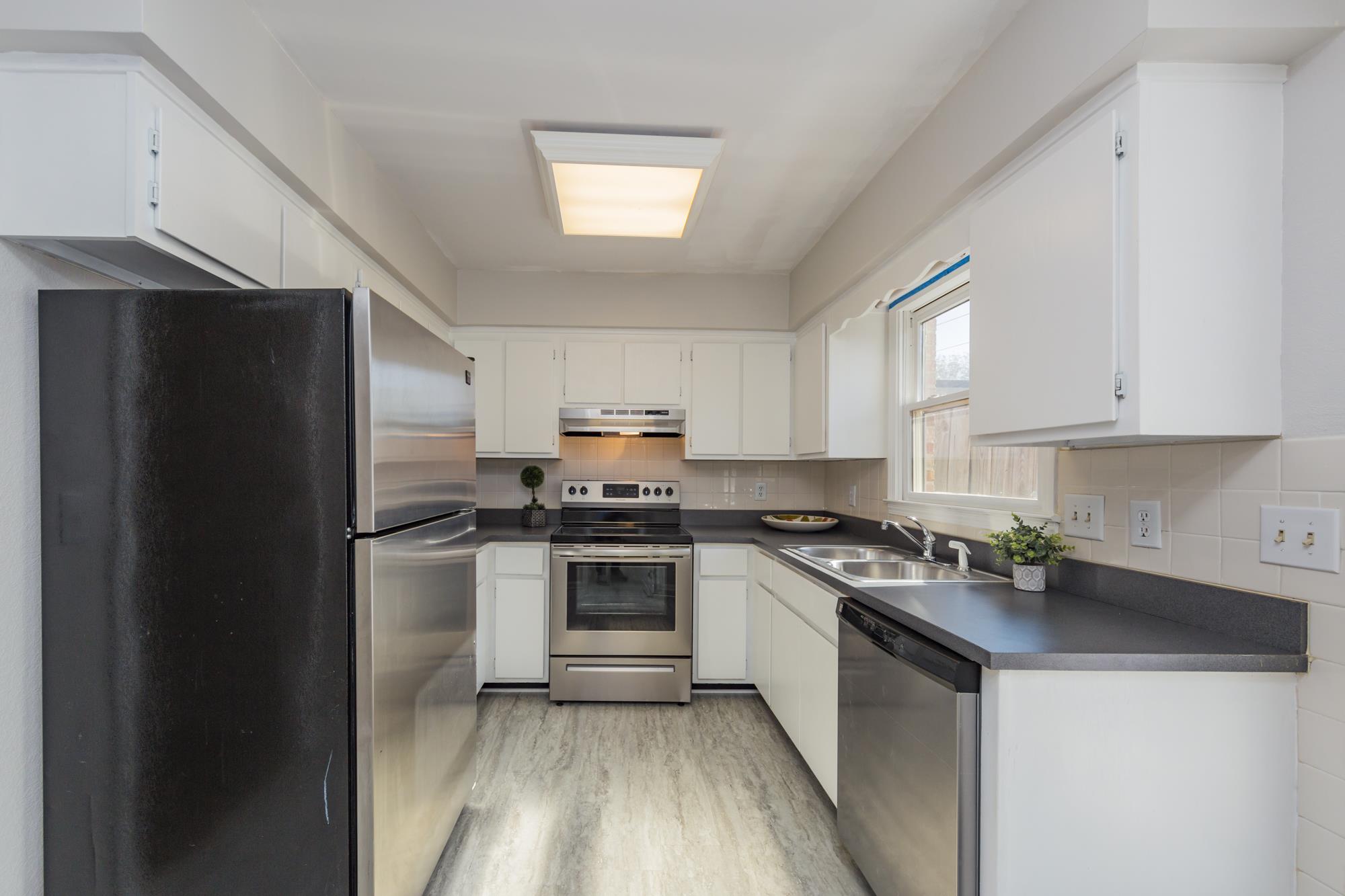 765 Kent Road, Unit 765 Nashville, TN 37214 - Photo 11 of 30 a kitchen with stainless steel appliances granite countertop a stove a refrigerator and a sink