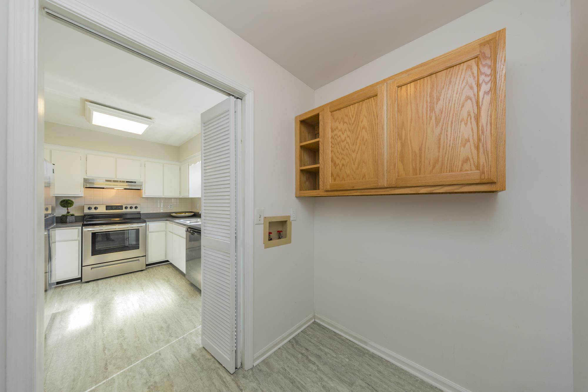 765 Kent Road, Unit 765 Nashville, TN 37214 - Photo 13 of 30 a view of a kitchen with a sink and dishwasher a stove top oven with wooden floor