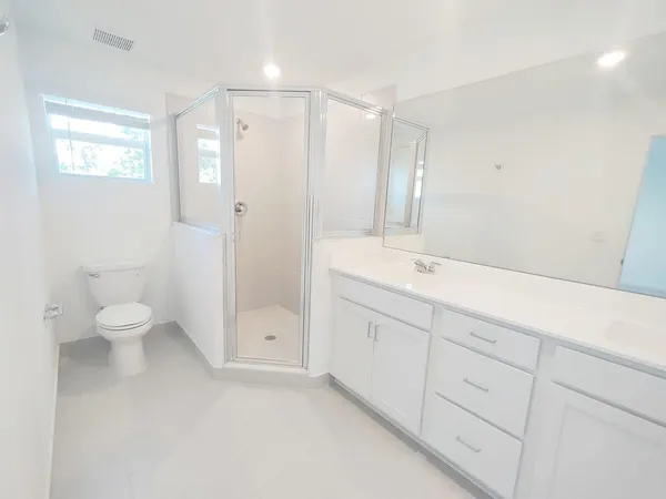 a bathroom with a granite countertop sink mirror and toilet
