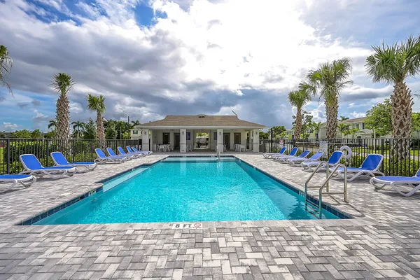 a view of a house with swimming pool and sitting area