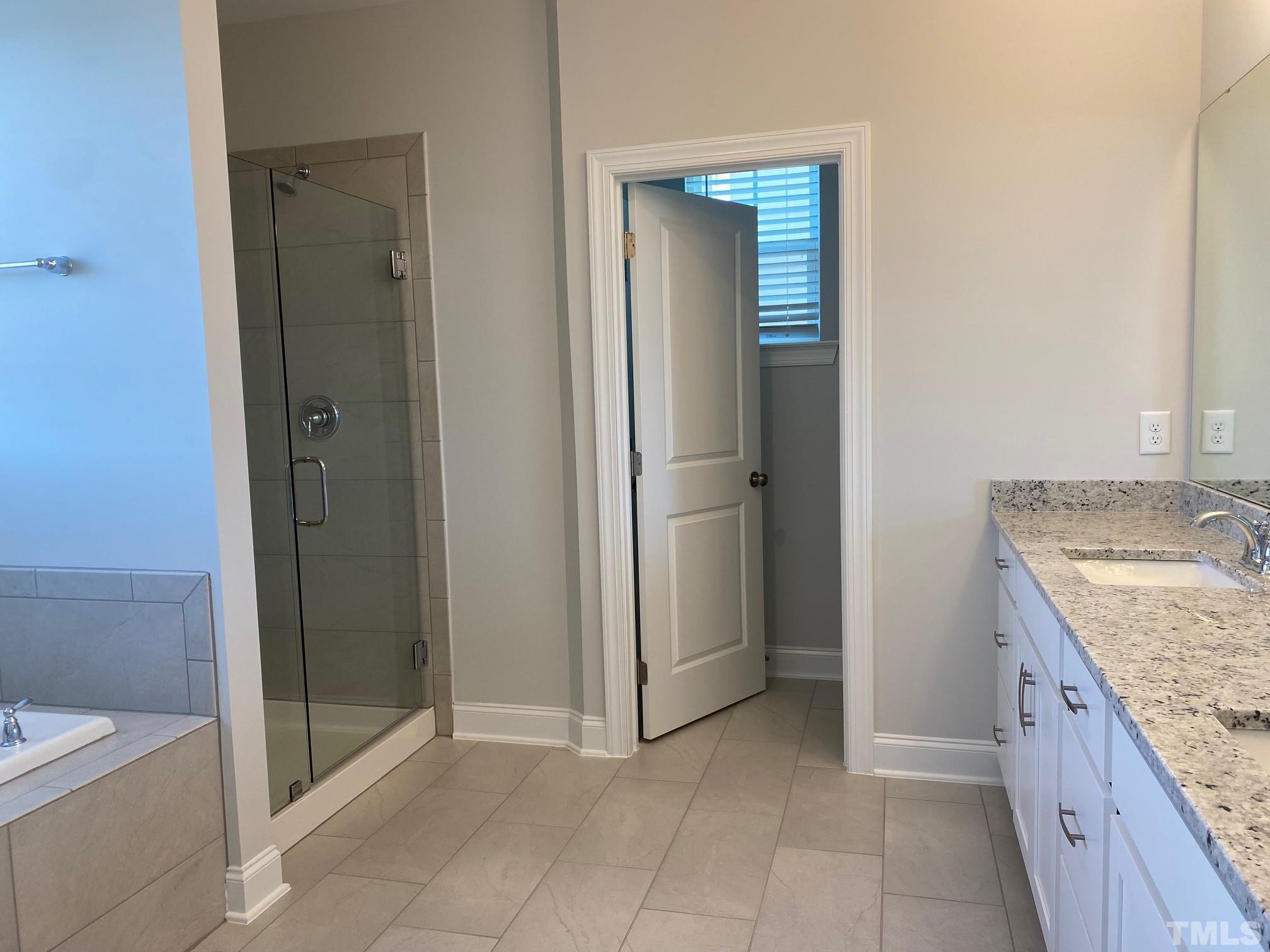 312 Ressler Street, Unit 504 Holly Springs, NC 27540 - Photo 11 of 30 a bathroom with a granite countertop sink and a mirror