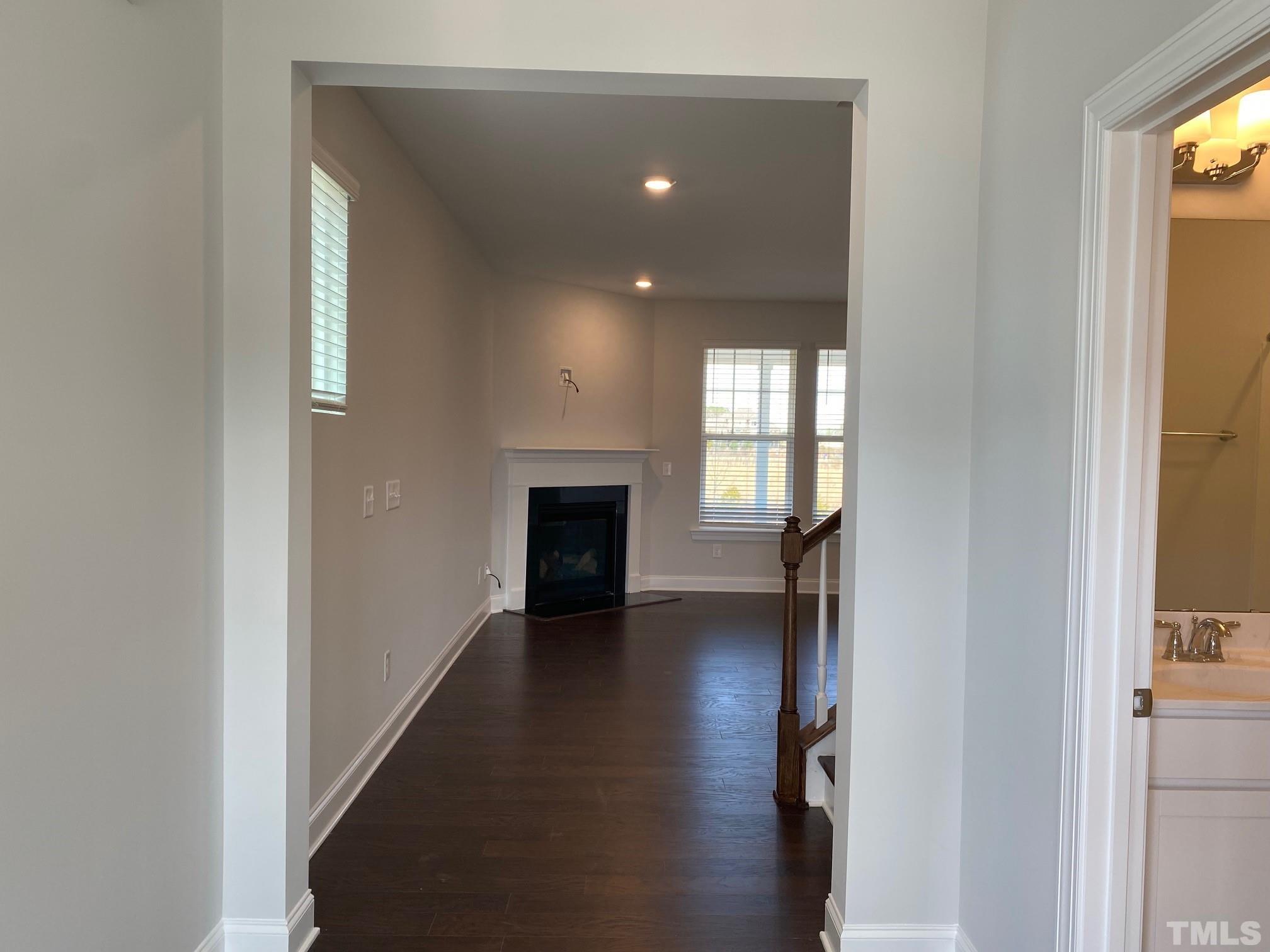 312 Ressler Street, Unit 504 Holly Springs, NC 27540 - Photo 3 of 30 a view of empty room with wooden floor and fireplace