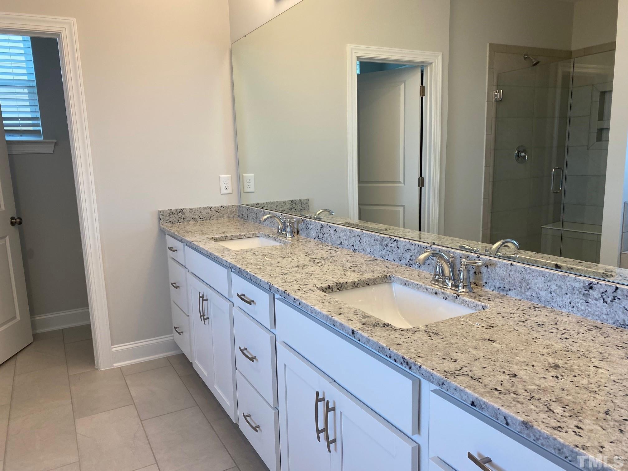 312 Ressler Street, Unit 504 Holly Springs, NC 27540 - Photo 10 of 30 a bathroom with a granite countertop sink and a mirror