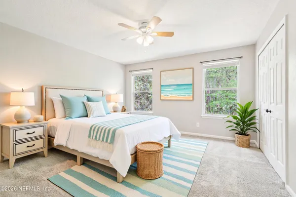 a bedroom with a large bed and potted plant