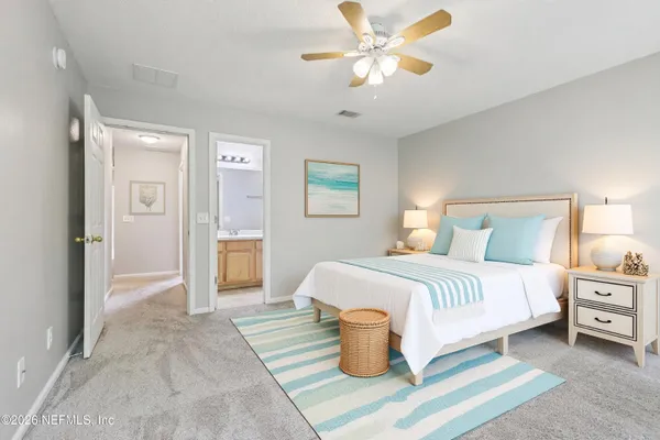 a spacious bedroom with a bed and a chandelier