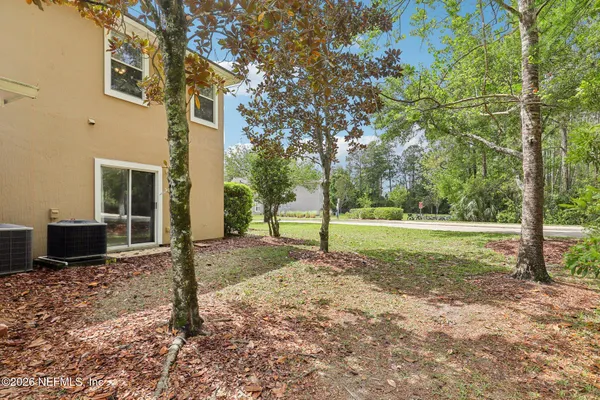 a view of a house with backyard and trees