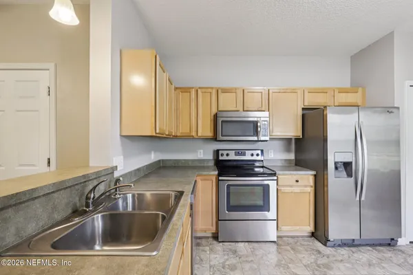 a kitchen with a sink stove and refrigerator