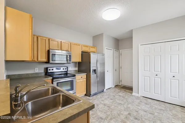 a kitchen with stainless steel appliances granite countertop a refrigerator and a sink