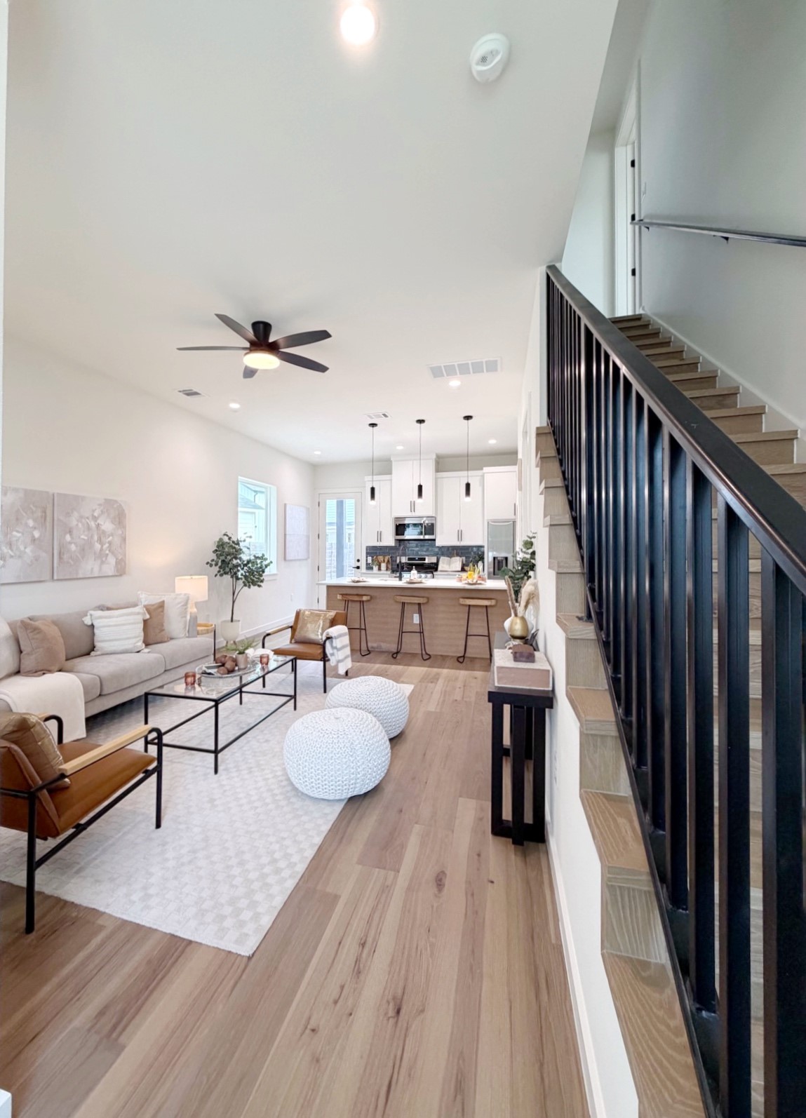 Bright, open-concept living space with sleek flooring seamlessly transitions to a modern kitchen.