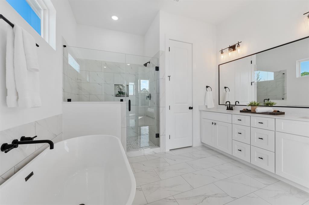 5618 Azores Houston, TX 77091 - Photo 1 of 38 a spacious bathroom with a granite countertop sink a mirror a bathtub and shower