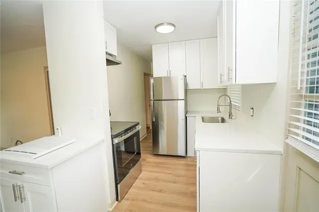 a kitchen with a refrigerator sink stove and cabinets