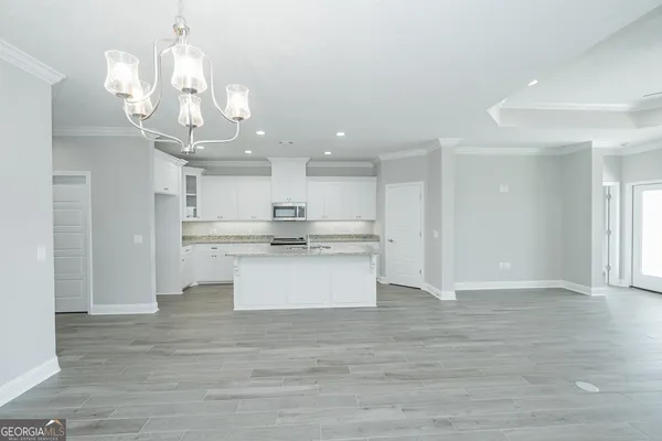 a large kitchen with kitchen island stainless steel appliances refrigerator and microwave