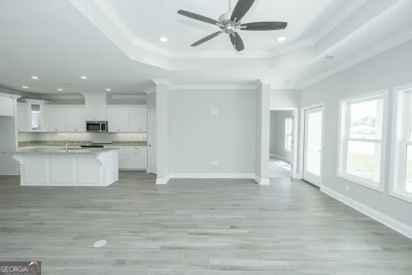 a view of kitchen with kitchen island white cabinets and stainless steel appliances