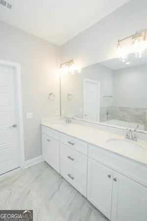 a spacious bathroom with double sink and a mirror