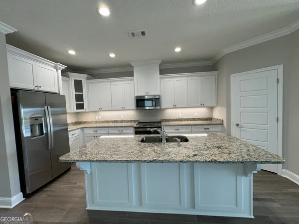 a kitchen with stainless steel appliances granite countertop a sink stove and refrigerator
