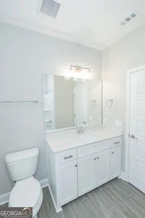 a bathroom with a toilet a sink and mirror