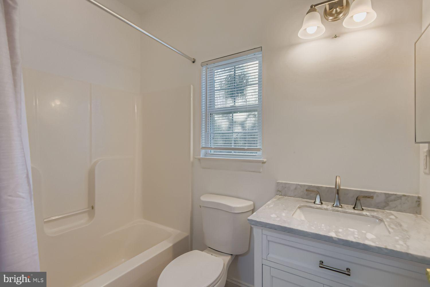 2218 Retreat Court Edgewood, MD 21040 - Photo 15 of 29 a bathroom with a granite countertop sink toilet a mirror and shower