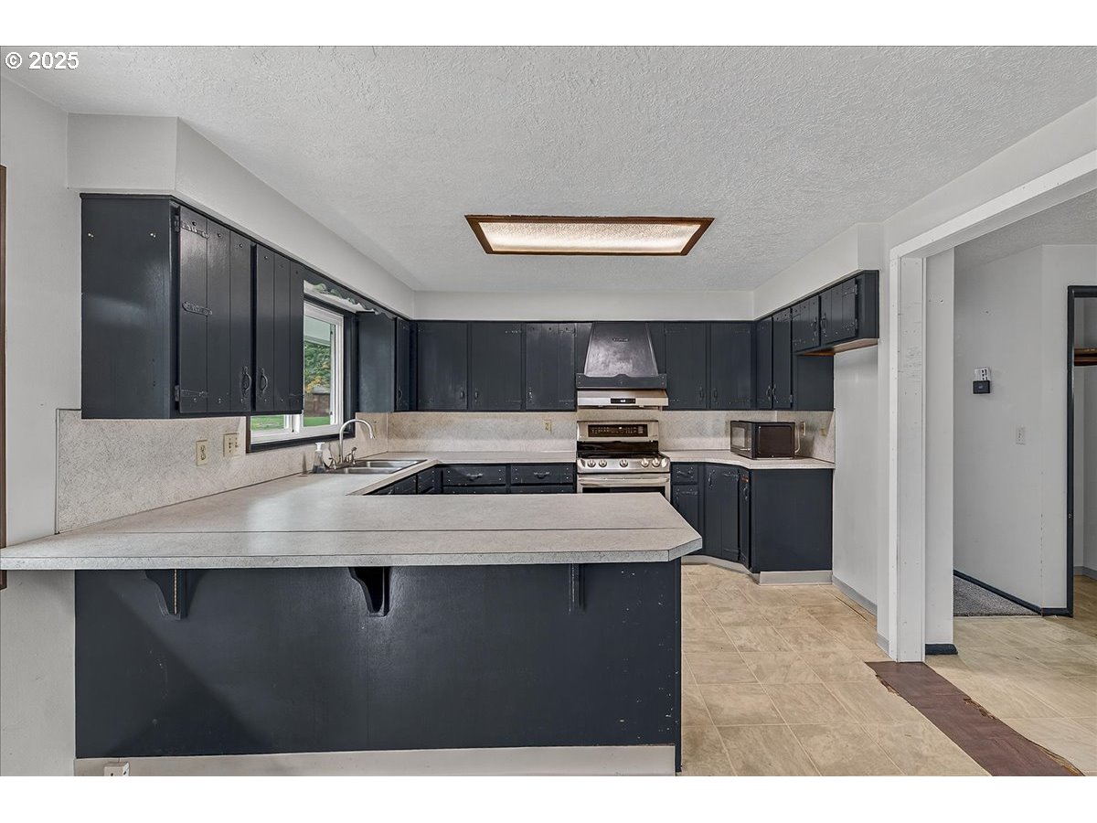 57827 South Bachelor Flat Road Warren, OR 97053 - Photo 22 of 38 a kitchen with stainless steel appliances kitchen island a sink stove and refrigerator