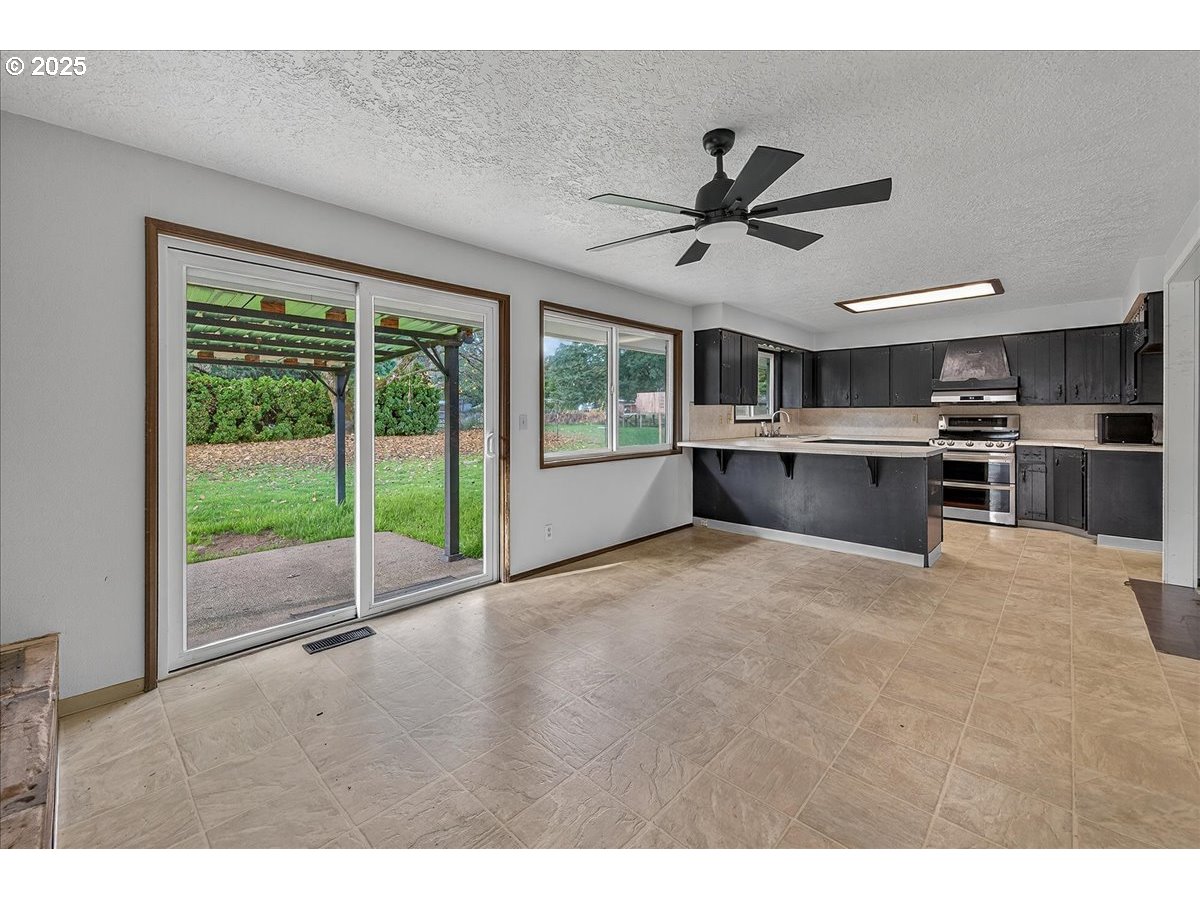 57827 South Bachelor Flat Road Warren, OR 97053 - Photo 28 of 38 a open kitchen with stainless steel appliances granite countertop a stove and a refrigerator