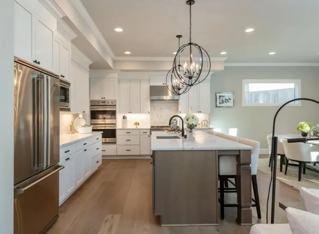 a kitchen with stainless steel appliances granite countertop a stove refrigerator and cabinets