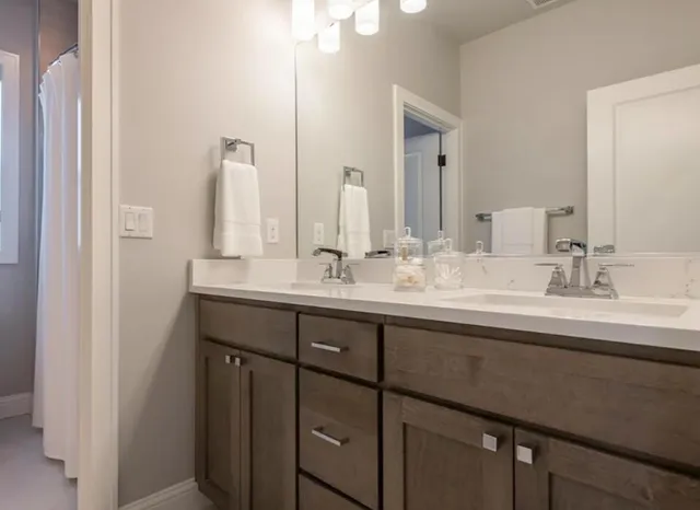 a bathroom with double sink and a mirror