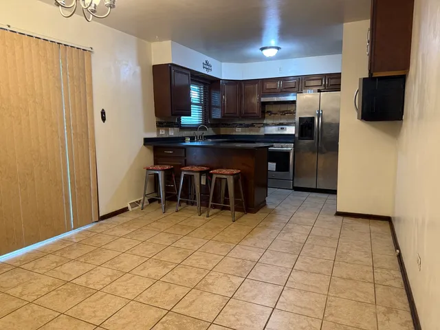a kitchen with stainless steel appliances a refrigerator and a stove top oven