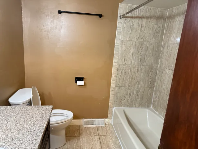 a bathroom with a toilet and a shower
