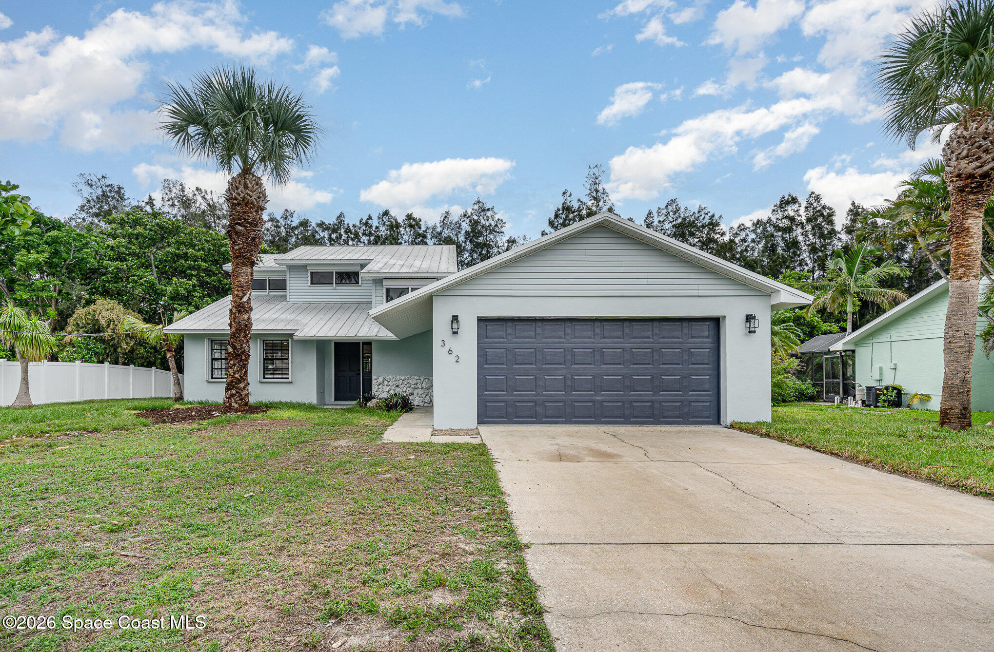 362 Nikomas Way Melbourne Beach, FL 32951 - Photo 1 of 32 a front view of a house with a yard and garage