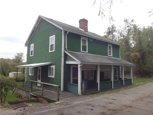 a view of house with a yard and sitting area